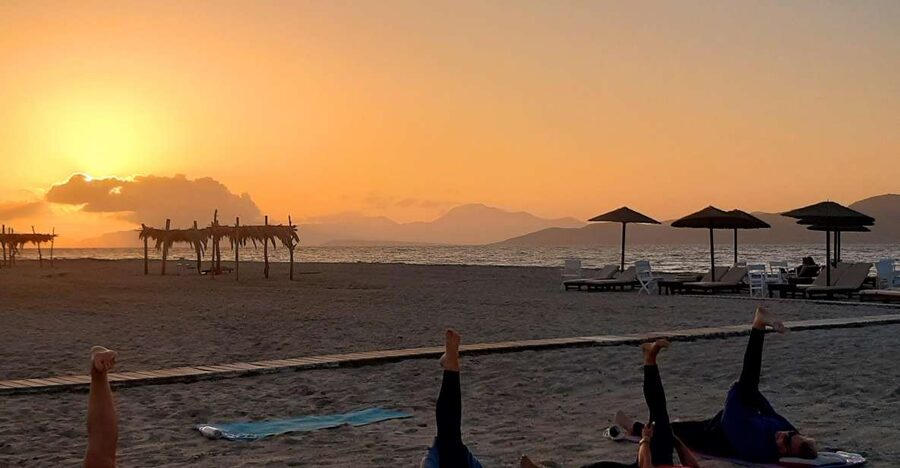 Sunset Pilates on Tigaki Beach - Tigaki Beach, Alikes Restaurant, and the Evexia flag